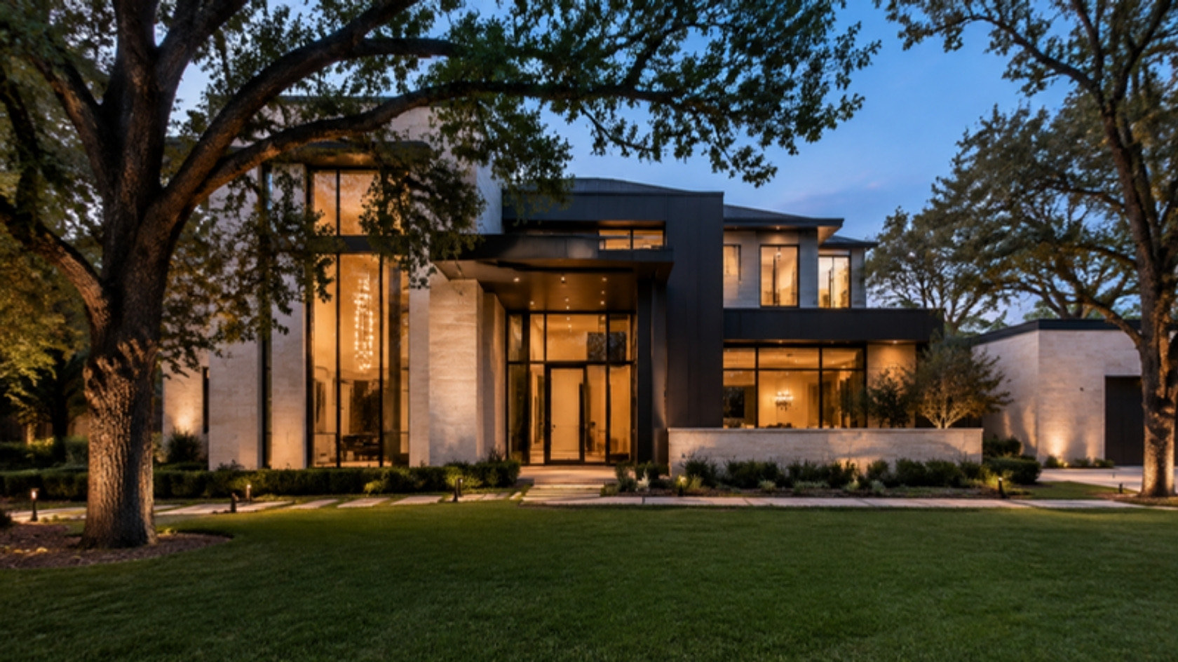 A modern home at dusk with warm light in every window